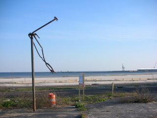 Road in front of beach with warped metal pole
