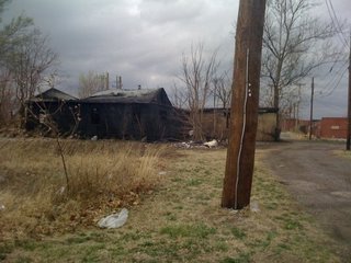 Partially burnt wooden building with pieces falling off of it